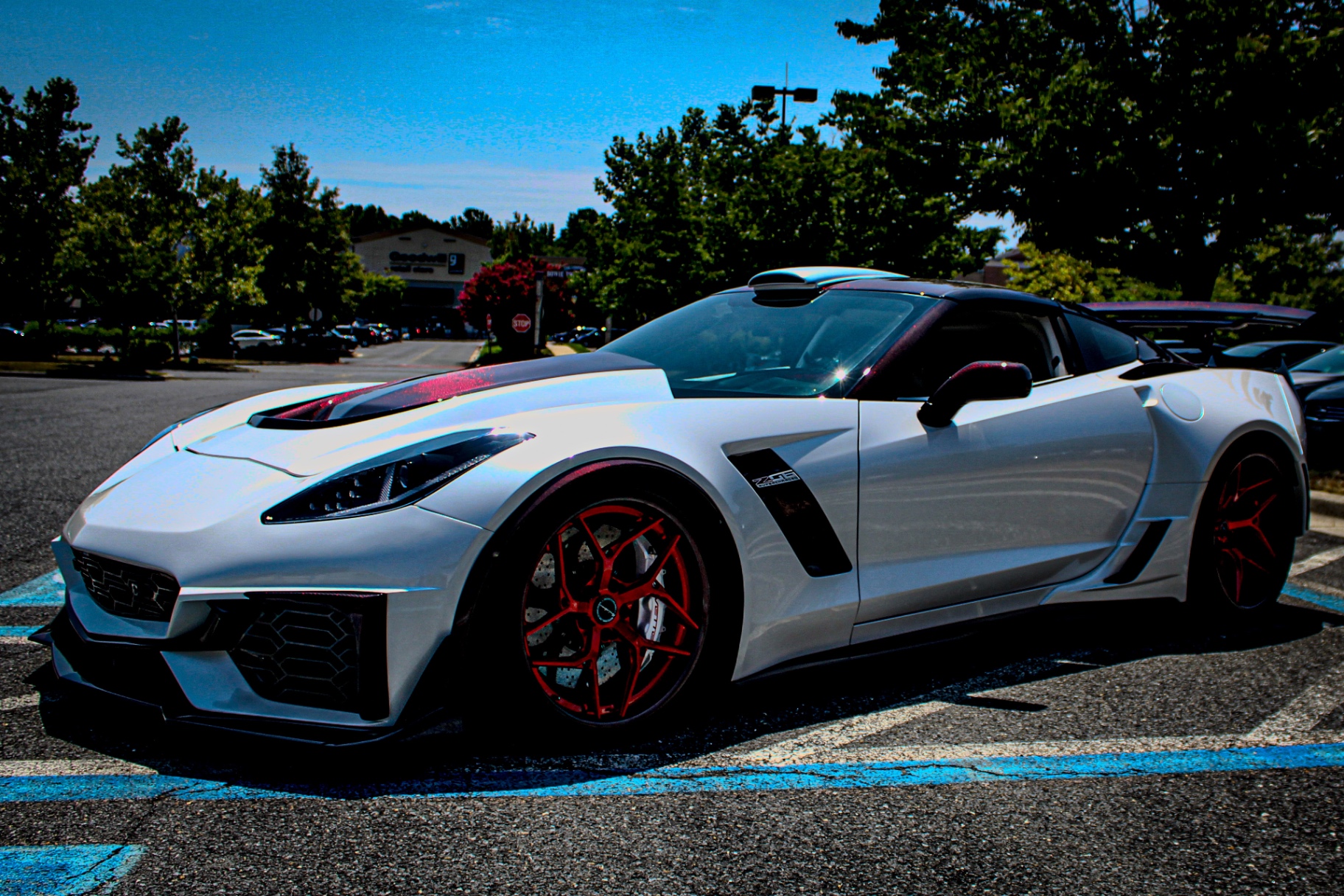 White Corvette with red wheels in daylight