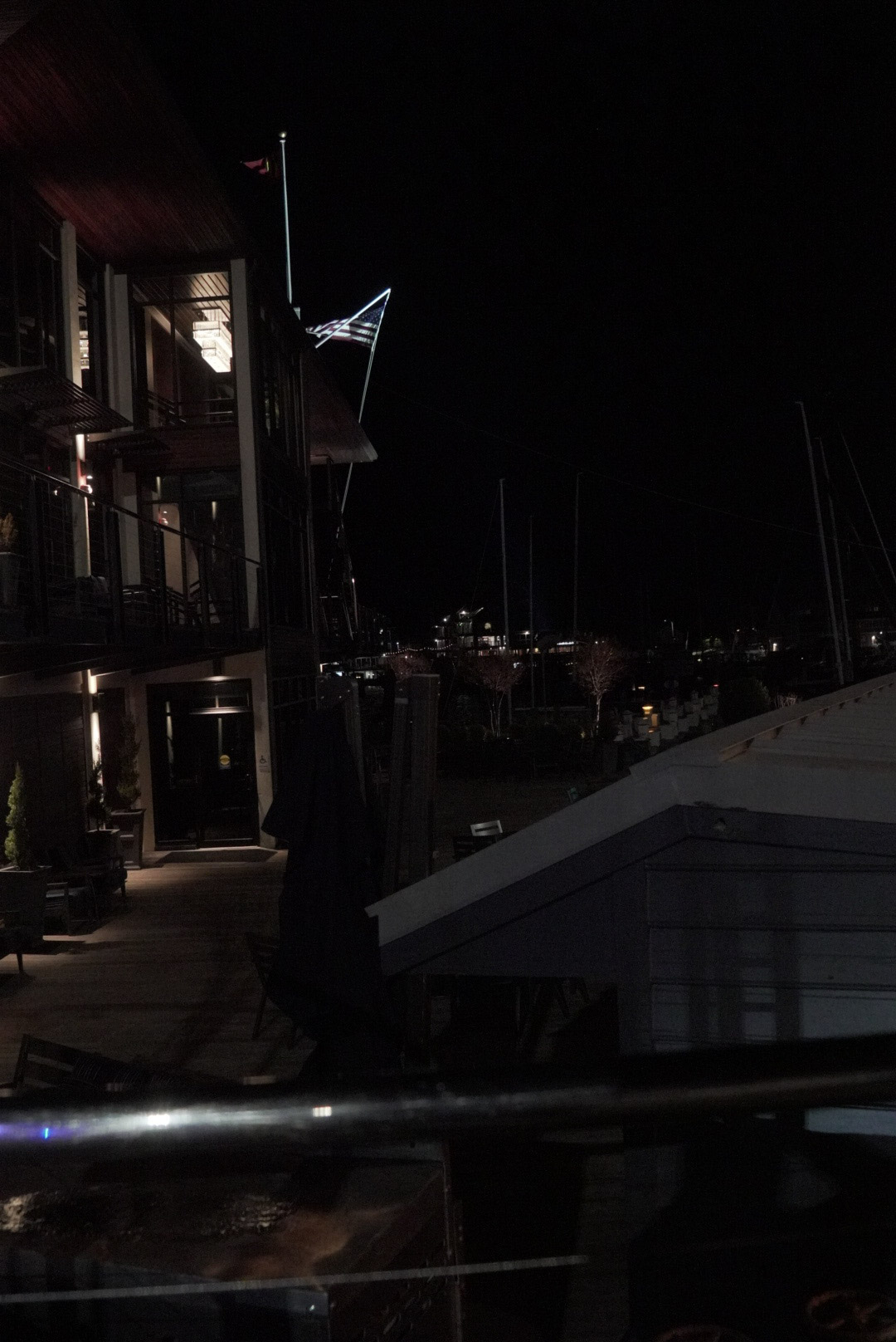 American flag waving over the marina at night