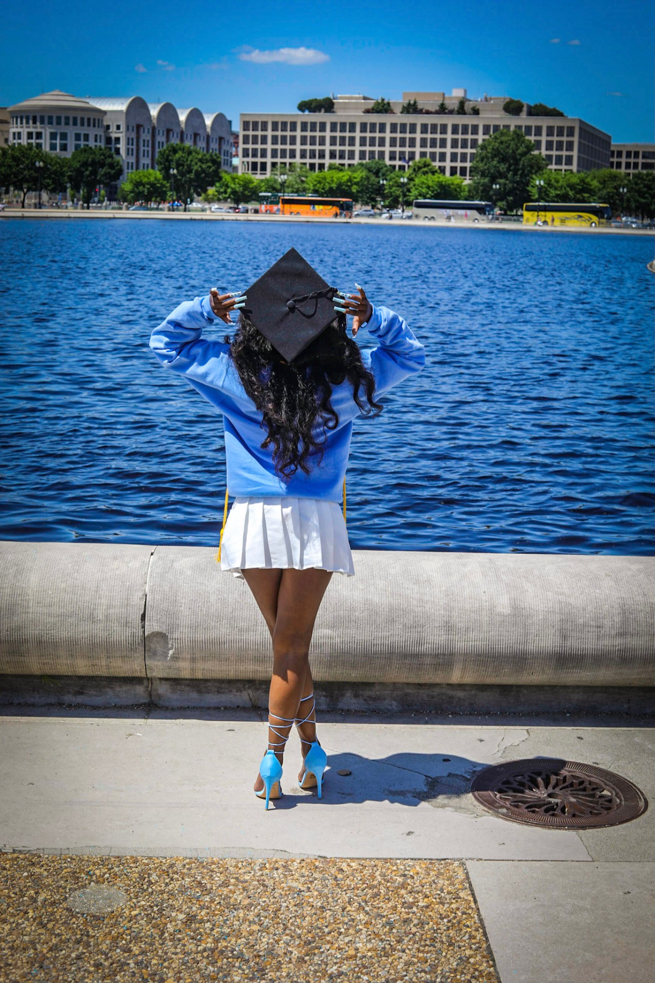 Graduation cap held high over the reflecting pool