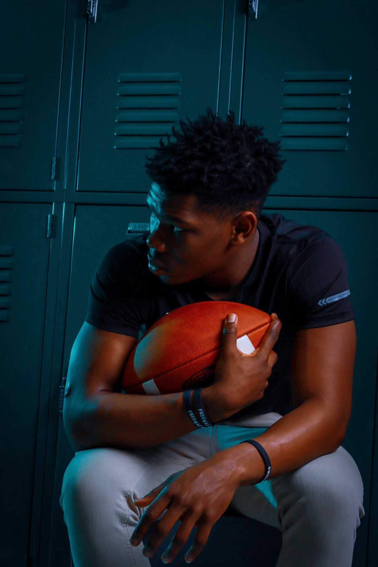 Locker room portrait holding football