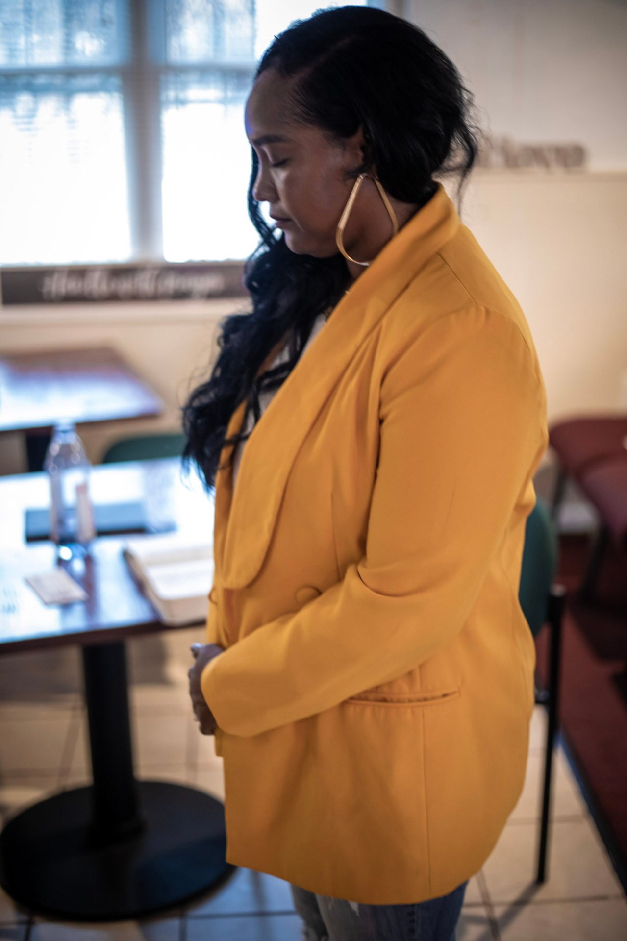 Quiet moment of prayer in a yellow blazer